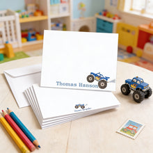 Load image into Gallery viewer, A set of personalized name cards with a monster truck design, along with a toy truck and some colored pencils, all placed on a table.