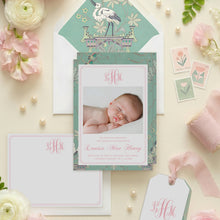 Load image into Gallery viewer, a collection of pink flowers, a baby announcement card, and stationery items arranged on a light-colored background.
